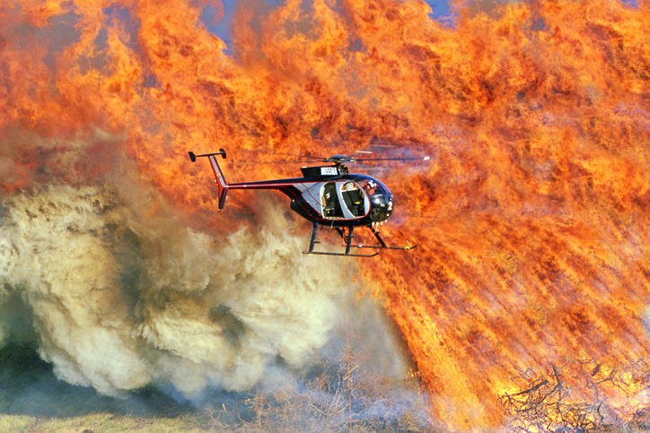 Helicopter flying over brush fire