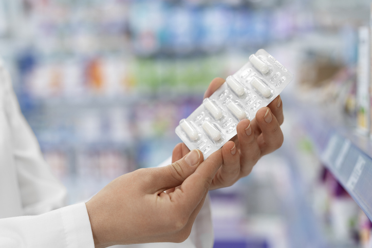 A person holding medical capsules at the pharmacy close up with a blurred background