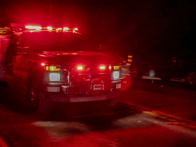 An Ambulance Rushing To The Scene Of An Accident On A Two Lane Highway After Dark With Lights Flashing And Siren Blaring