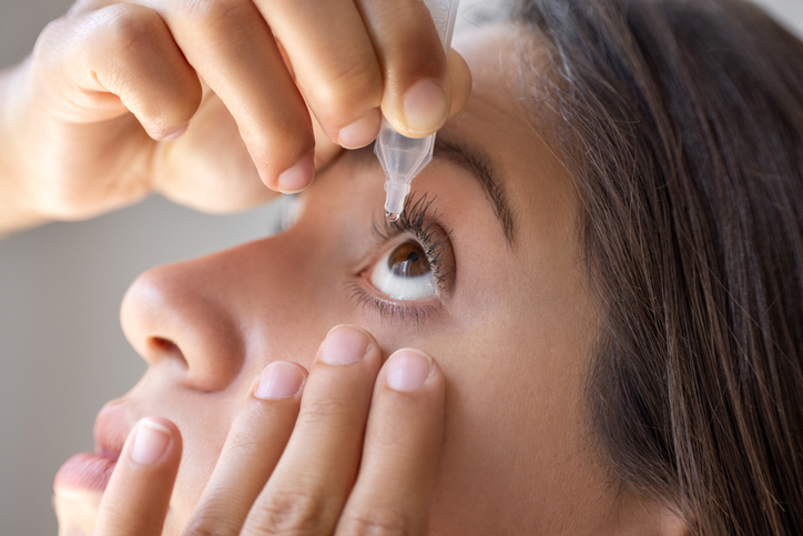 Ophthalmology. A woman instills medicine into her eye.