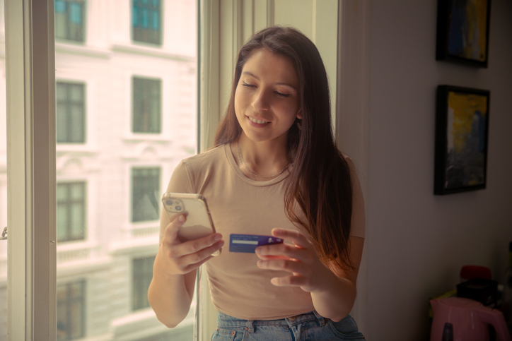 Young woman using smartphone to buy online