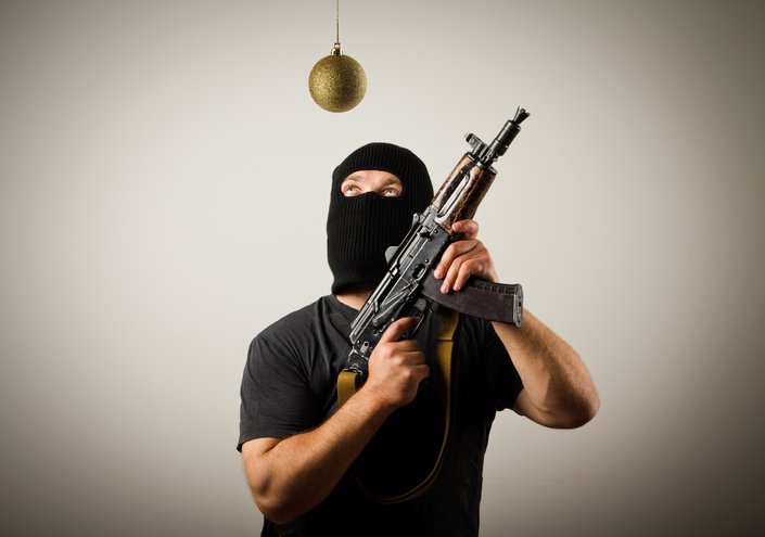 Man in mask with gun and Christmas toy.