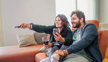 Newlyweds Relaxing at Home with Wine and Television