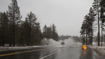 Vehicle Driving through Flooded Road During Atmospheric River Event in Sierra Nevada Mountains