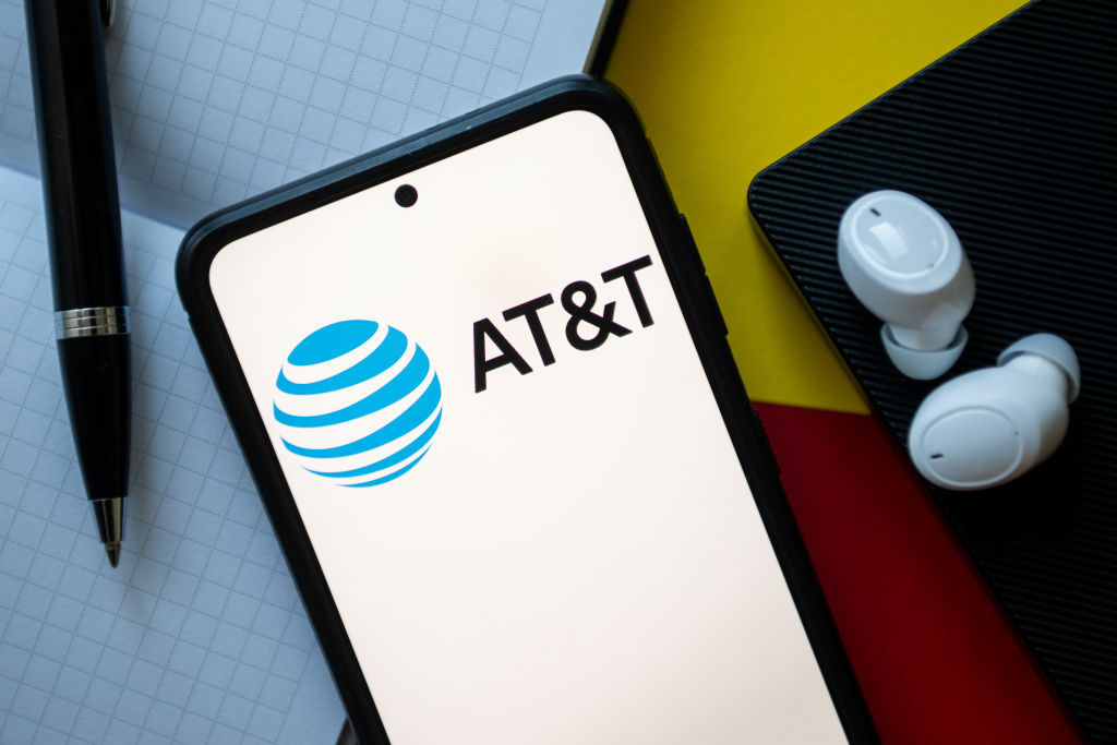 In this photo illustration an AT&T logo seen displayed on a...