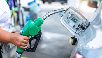 Hand refilling the white car with fuel at the gas station. Oil and gas energy. Fill a small truck with diesel fuel for transportation.
