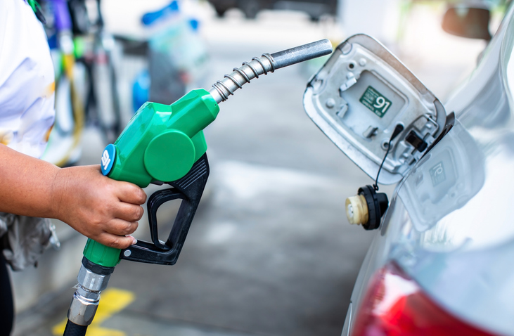 Hand refilling the white car with fuel at the gas station. Oil and gas energy. Fill a small truck with diesel fuel for transportation.