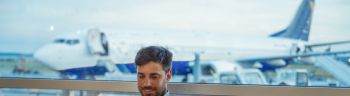 Young businessman at the airport waiting for the flight. Businessman using smart phone
