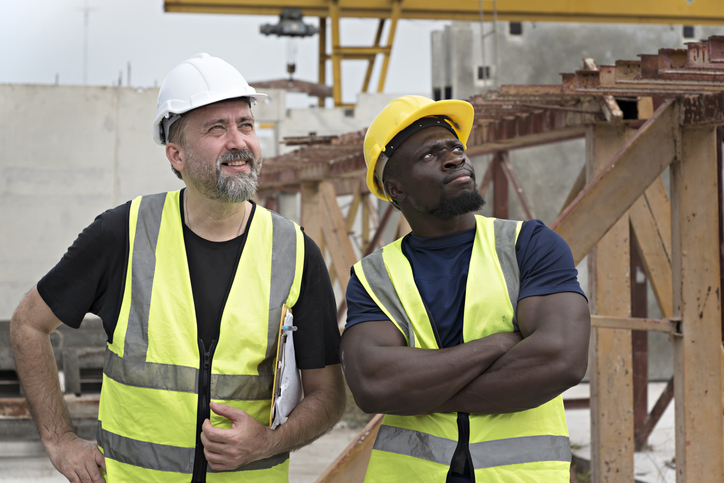 Portrait of two male workers at factory plant.