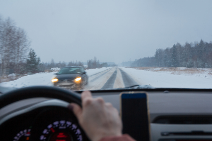 Steering wheel control on a snowy highway in the countryside