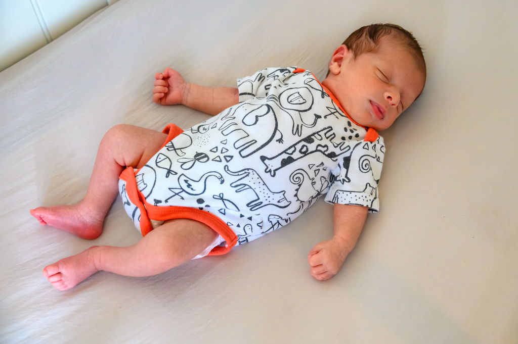 A baby boy quietly sleeping in his cradle...