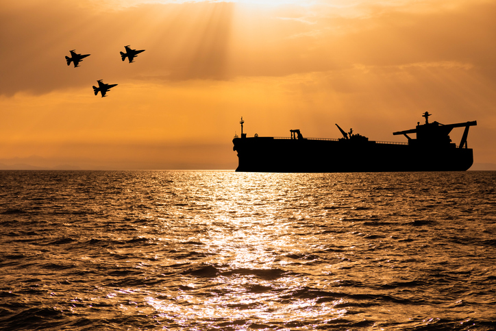 Oil tanker at sea and fighter jets