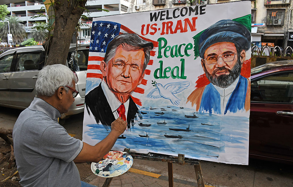 A teacher from the Gurukul School of Art paints a poster