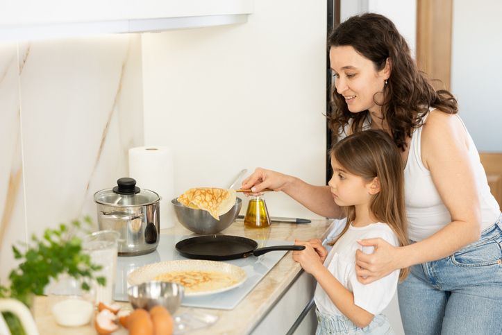 Mom and her daughter fry pancakes