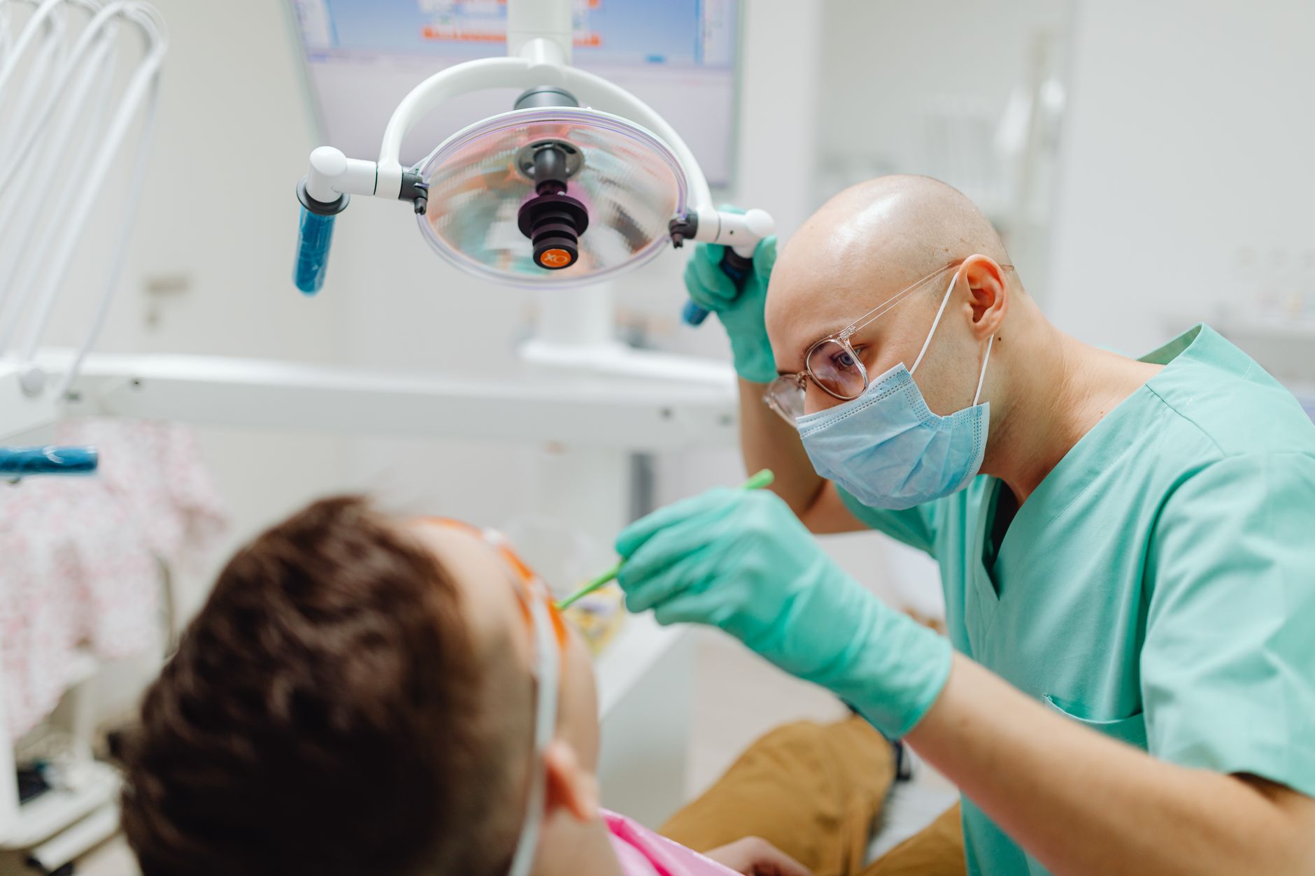 dentist in mask diagnosing patient