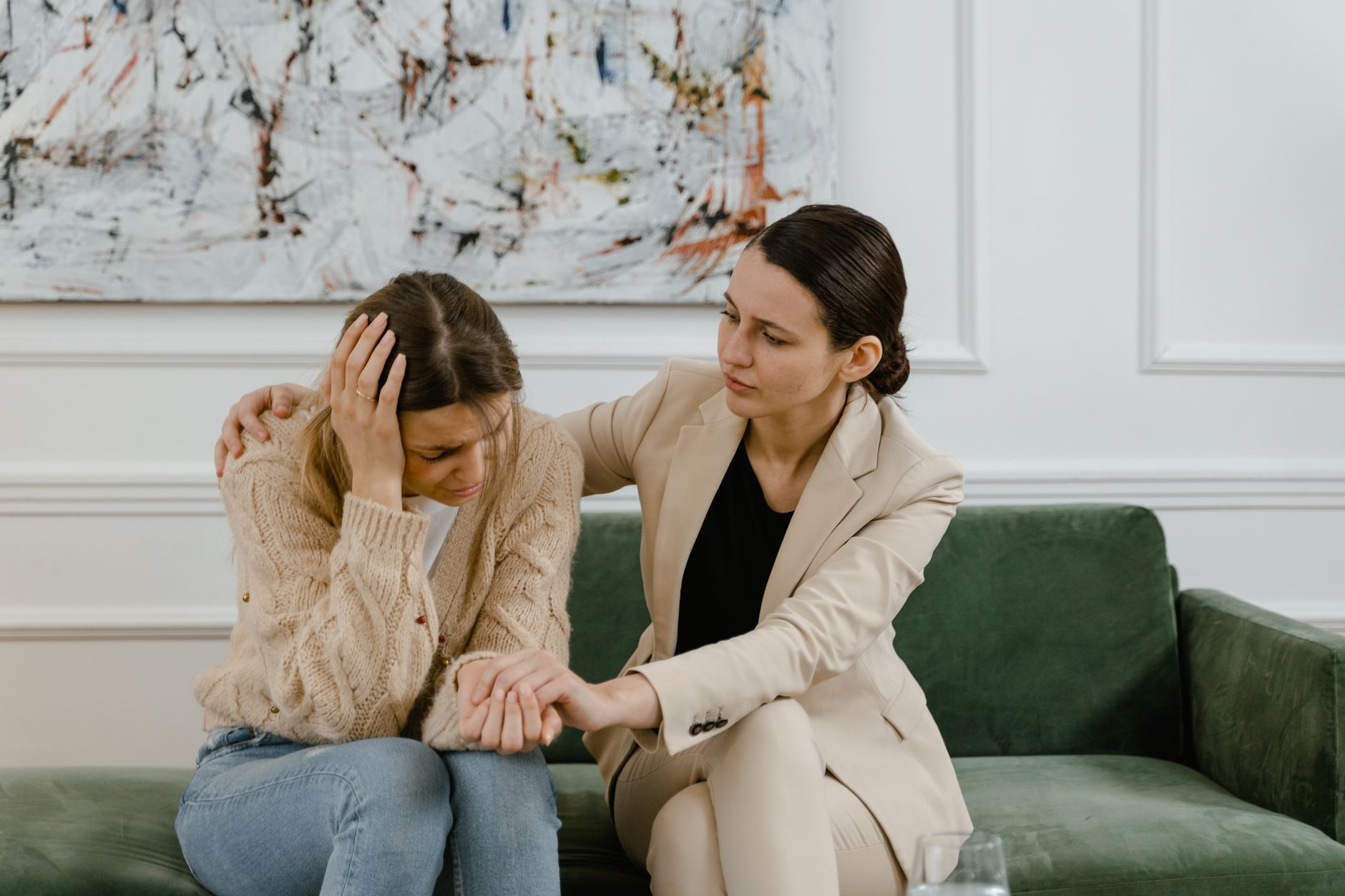 two women talking while sitting on the sofa