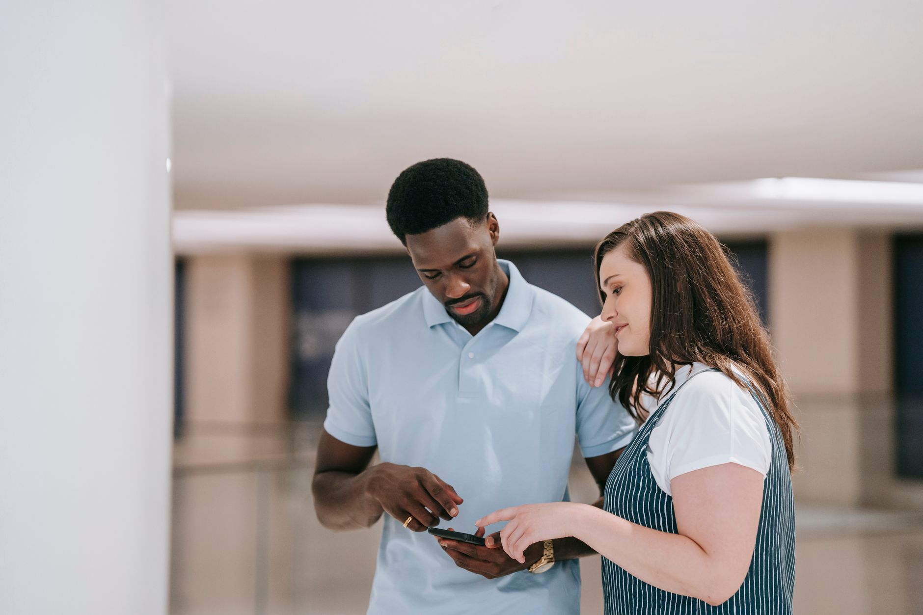 man and woman looking at the screen of a mobile phone