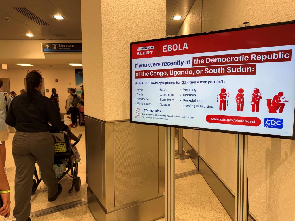 A health alert sign in an airport terminal advising travelers who recently visited the Democratic Republic of the Congo, Uganda, or South Sudan to watch for Ebola symptoms for 21 days after leaving those areas.